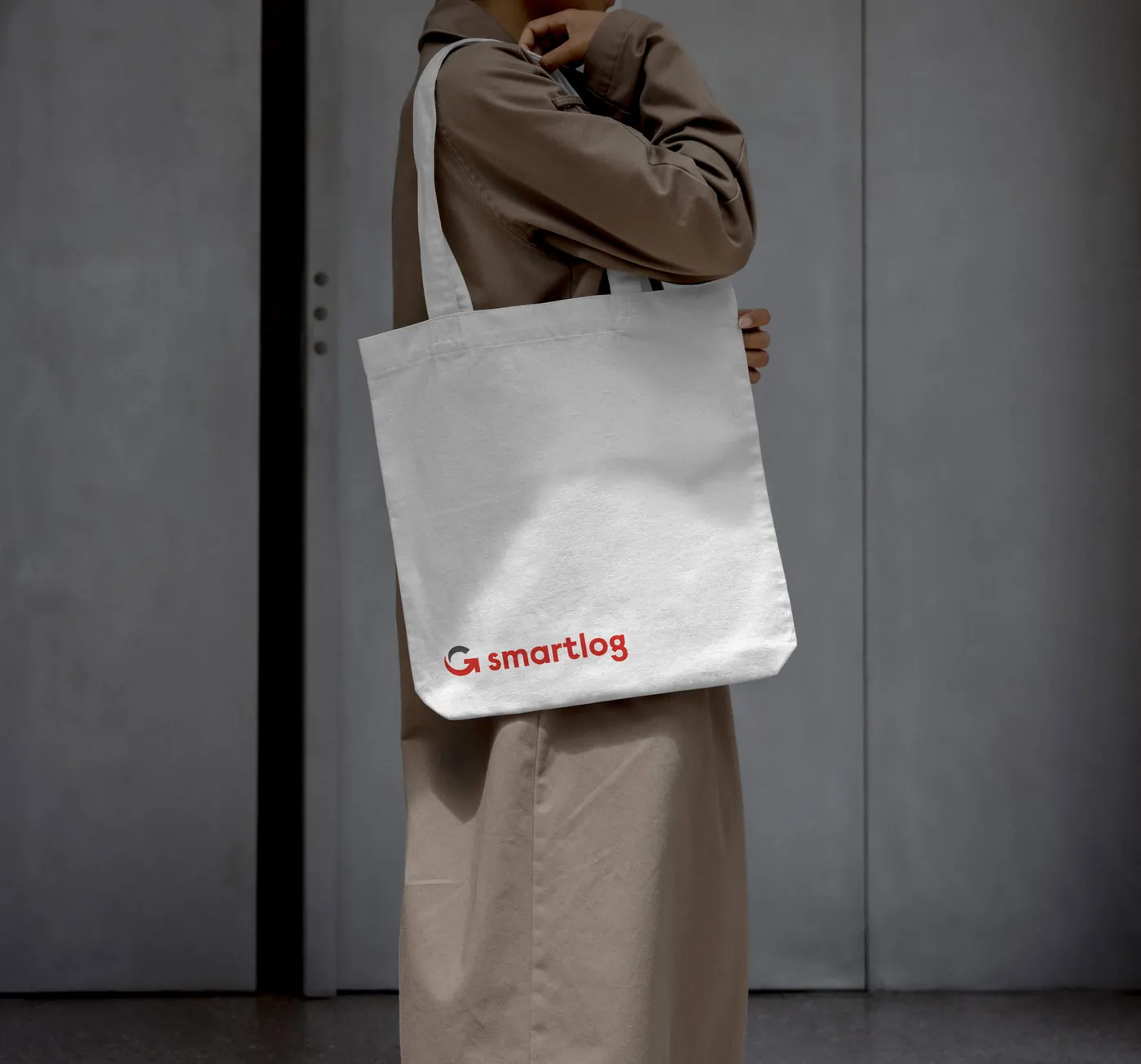 Bolsa de tela blanca con el logotipo de SmartLog, colgada al hombro